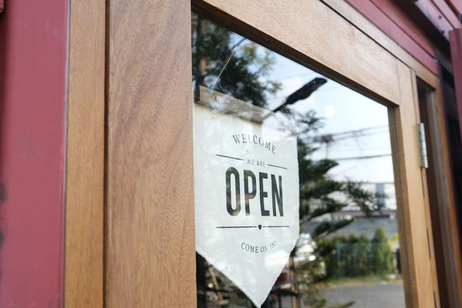 A wooden door with a sign on it that says open