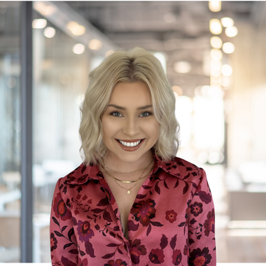 A woman in a pink floral shirt is smiling in a circle