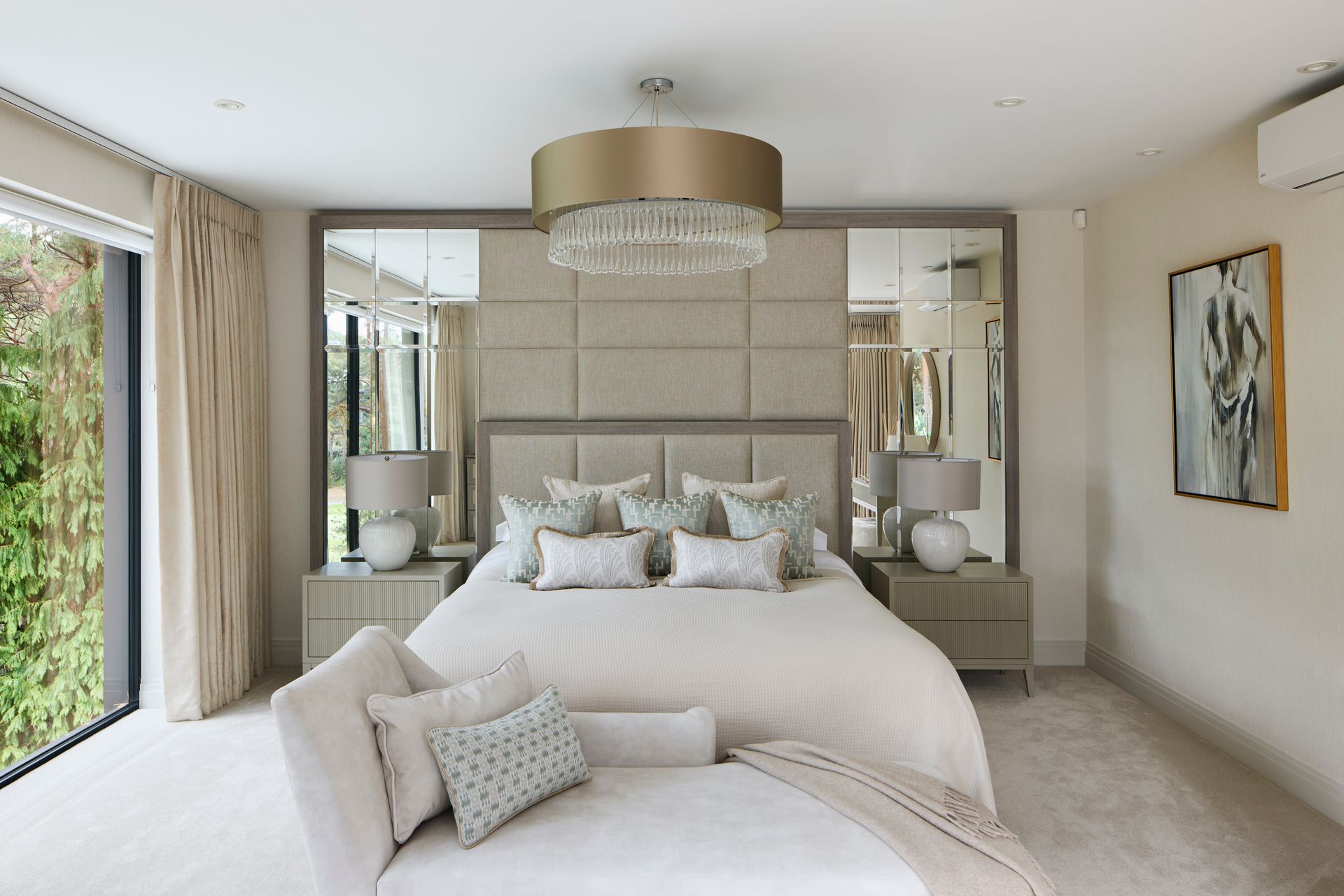 Bright modern bedroom with a large upholstered bed, mirrored nightstands, and beige decor