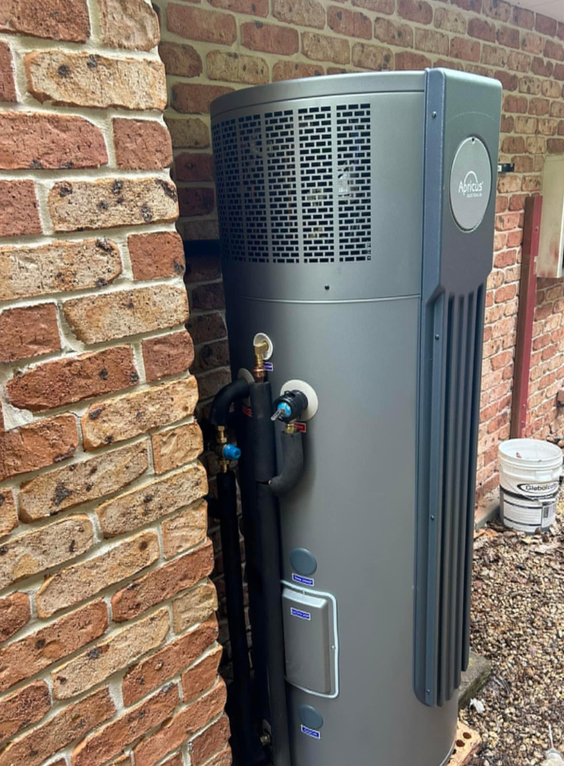 Person Draining Water Heater With a Hose in a Utility Room With Insulation — B&A Plumbing and Gas In Wauchope, NSW