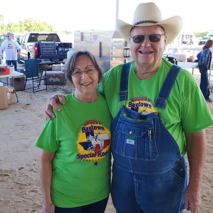 A smiling couple wearing matching green t-shirts with