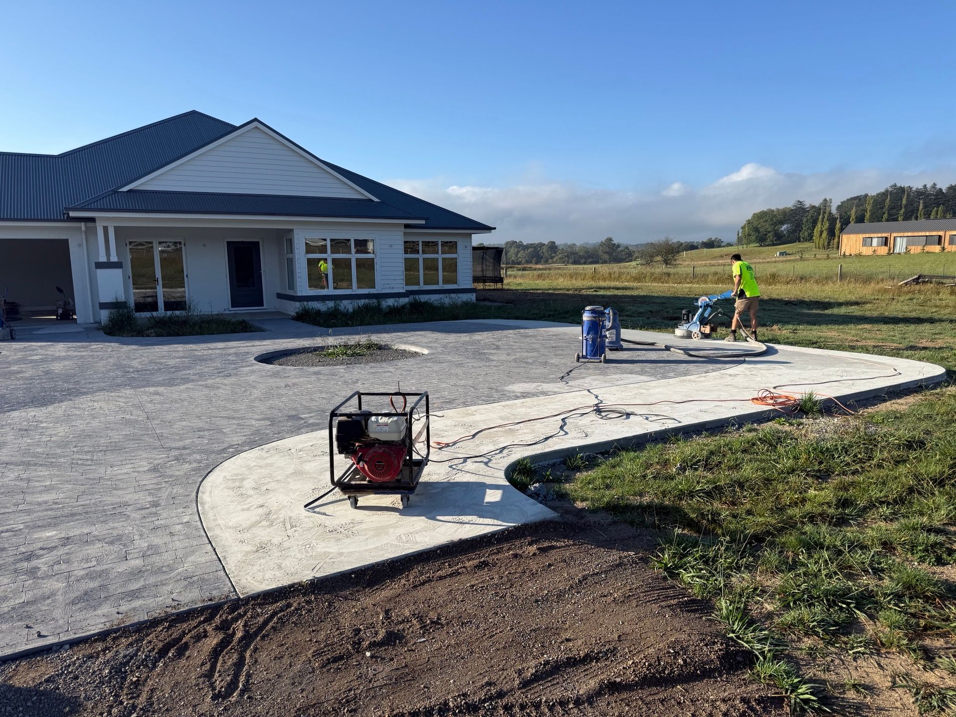 A Concrete Patio Is Being Built in The Backyard of A House — Illawarra Resurfacing Pty Ltd in Balgownie, NSW