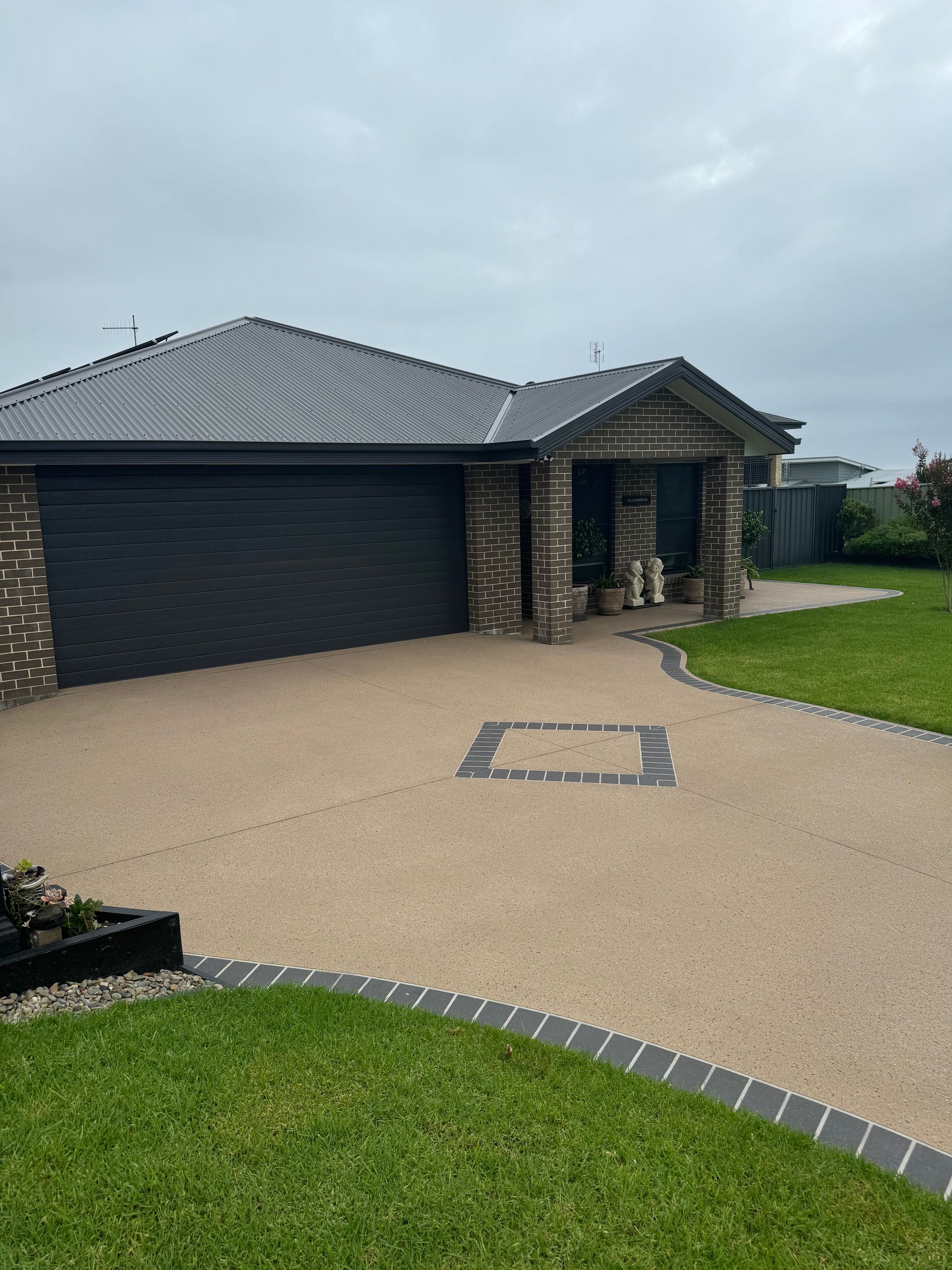 A Driveway Leading to A House on A Sunny Day — Illawarra Resurfacing Pty Ltd in Balgownie, NSW