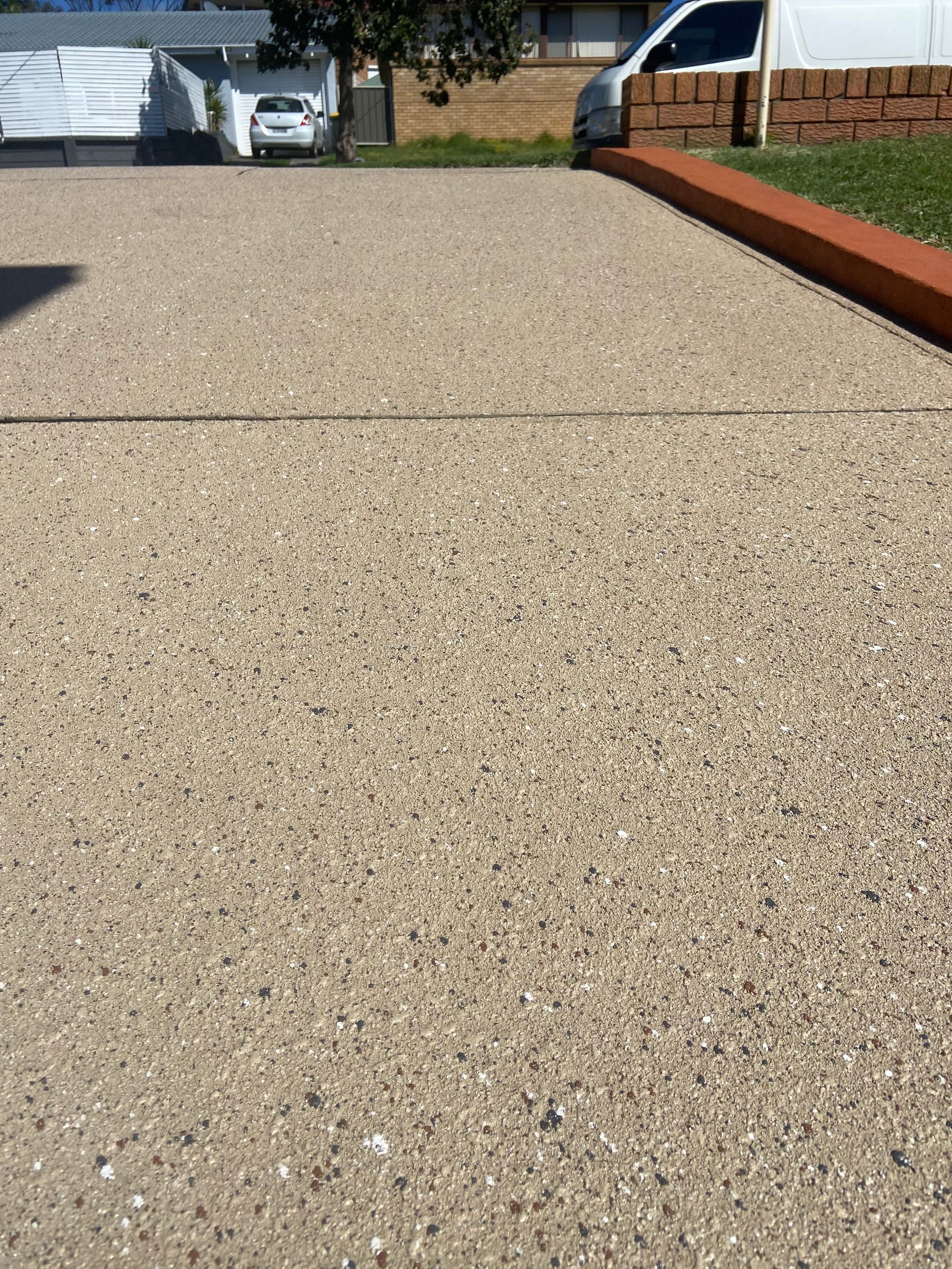 A Concrete Driveway with A Tape In Front Of It — Illawarra Resurfacing Pty Ltd in Balgownie, NSW