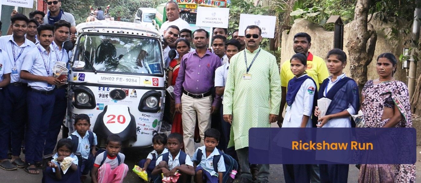 Group of people posing with a small vehicle;