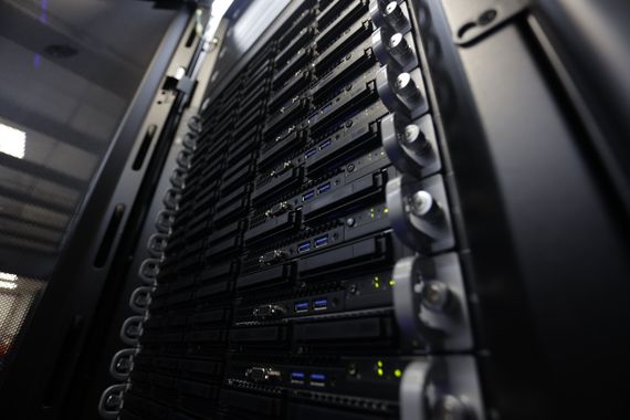 Server racks in a data center, rows of black computer hardware.