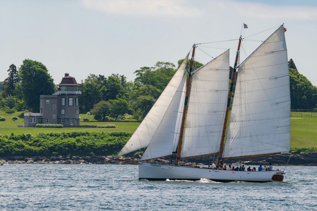 A sailboat in the water with a house in the background