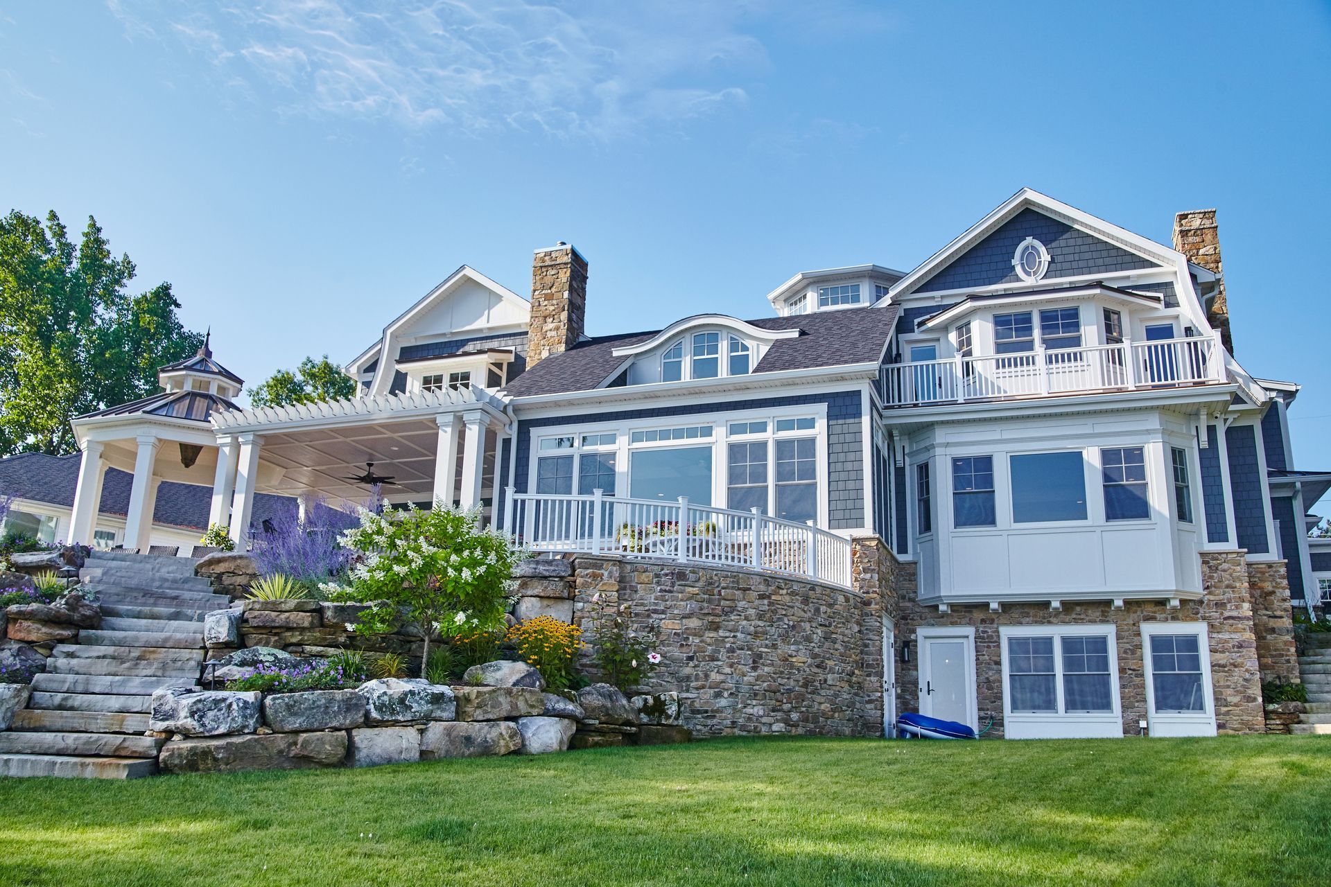 A large house is sitting on top of a lush green hillside.