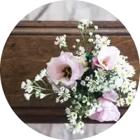 A bouquet of pale pink and white flowers arranged on a wooden table.