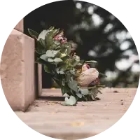 Wedding bouquet of white and pink flowers resting on a stone ledge outdoors