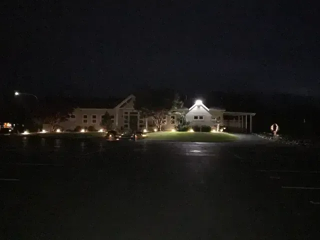 Nighttime view of a lit building complex across a dark field