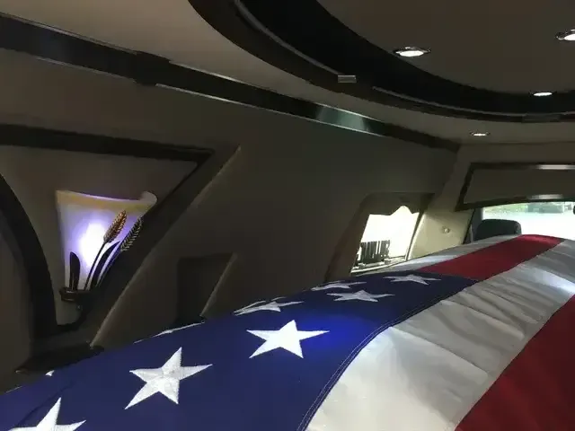 Folded American flag inside a car with dark interior and lit ceiling accents.
