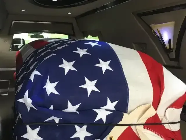 American flag-draped casket in a hearse interior