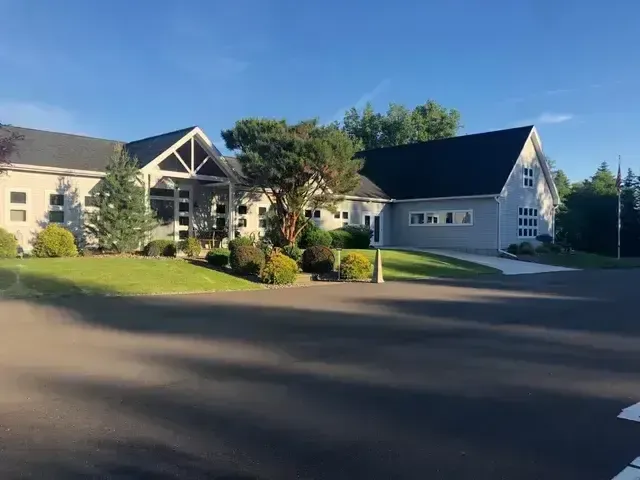 Suburban apartment and garage buildings beside a paved road on a sunny day
