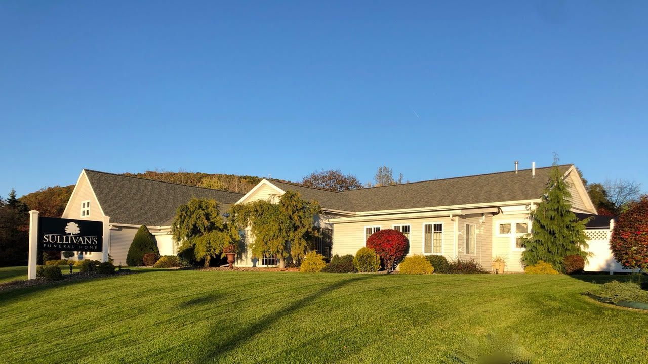 Single-story beige house with a green lawn under a clear blue sky