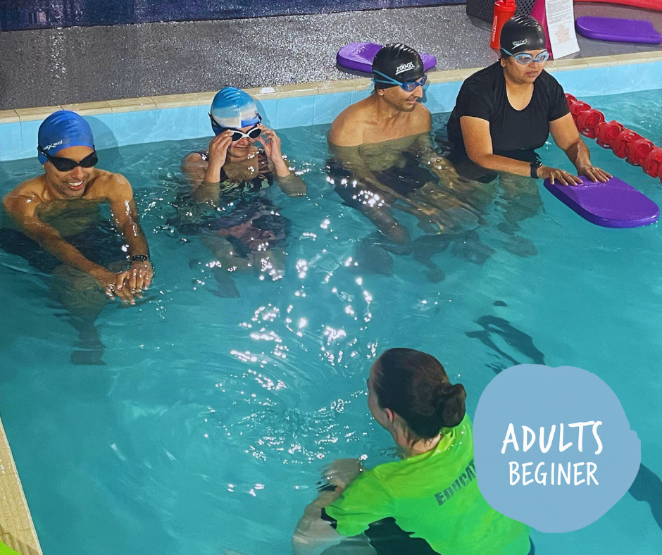 Woman in a swimming cap and goggles in a pool, holding onto a lane rope.