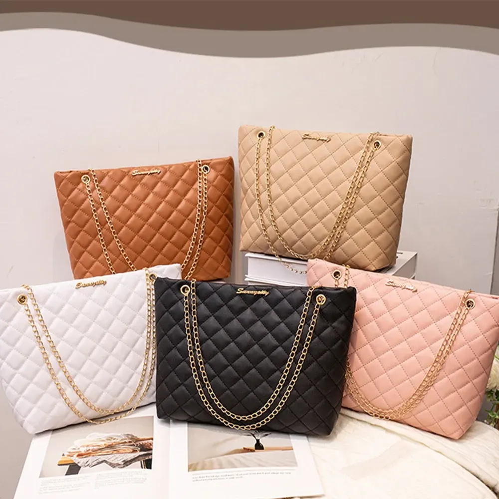 Five quilted handbags in white, black, pink, tan, and brown on a tabletop display