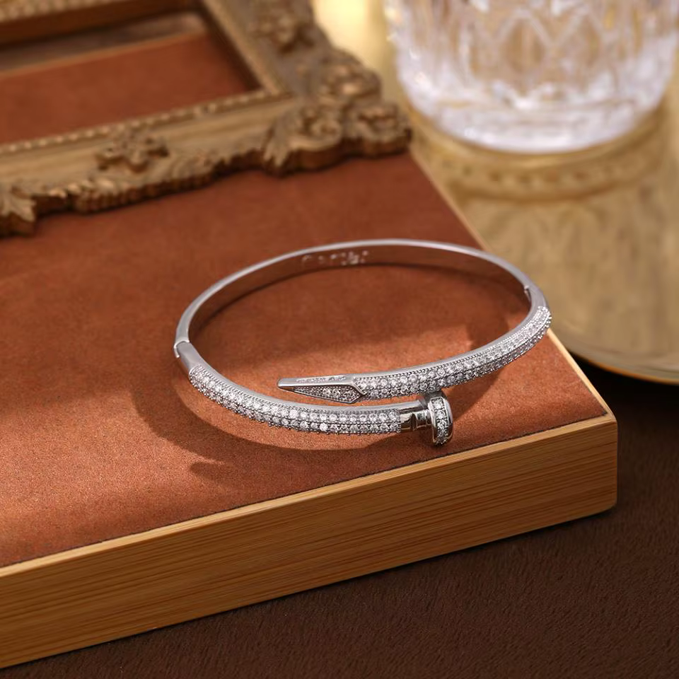 Silver diamond bracelet on a brown book with a decorative frame in the background