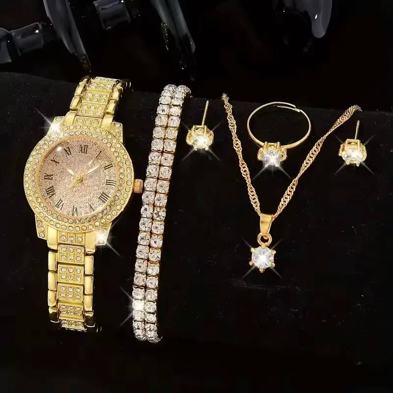 Gold watch, bracelet, necklace, and ring set with star-shaped stones on a black background