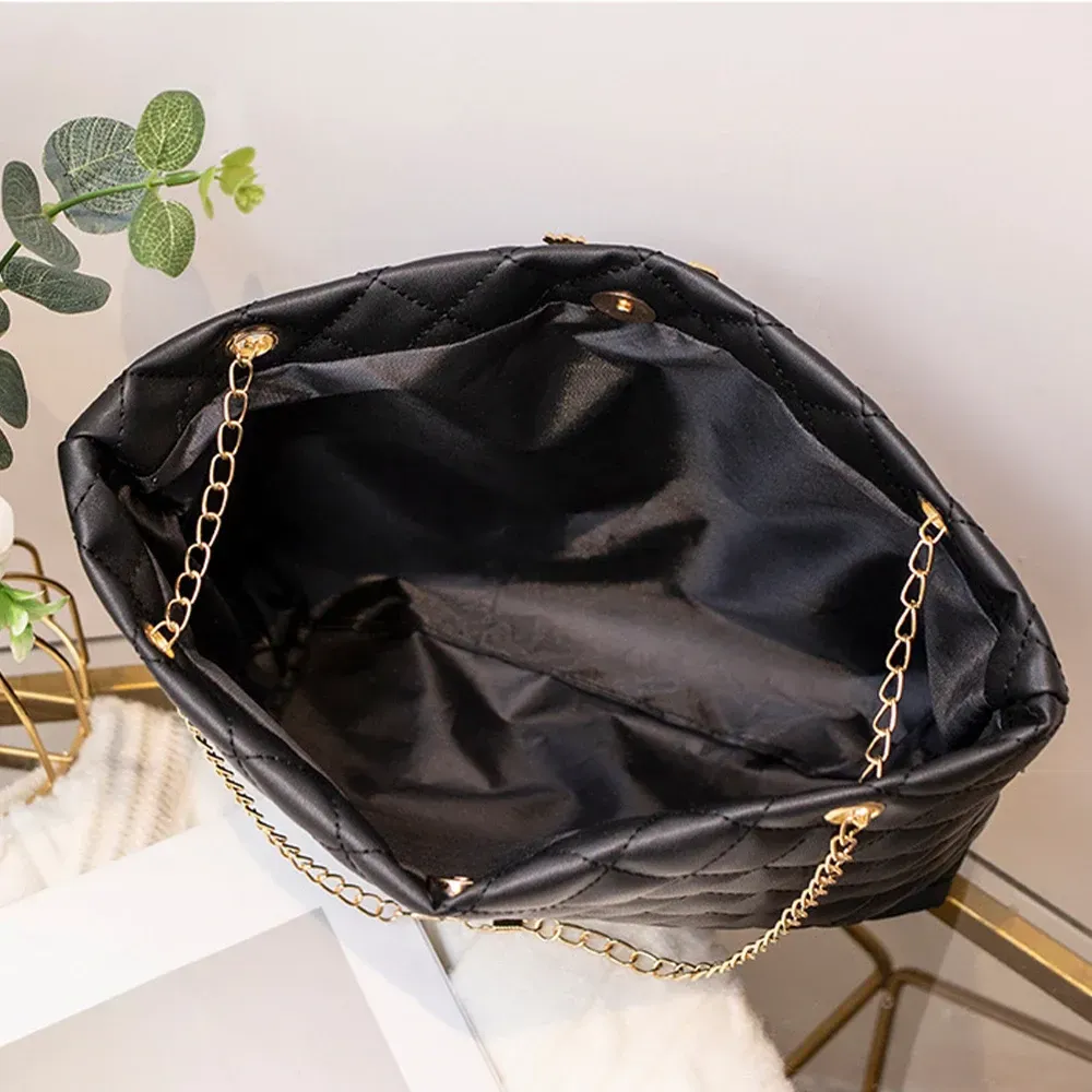 Five quilted handbags in white, black, pink, tan, and brown on a tabletop display