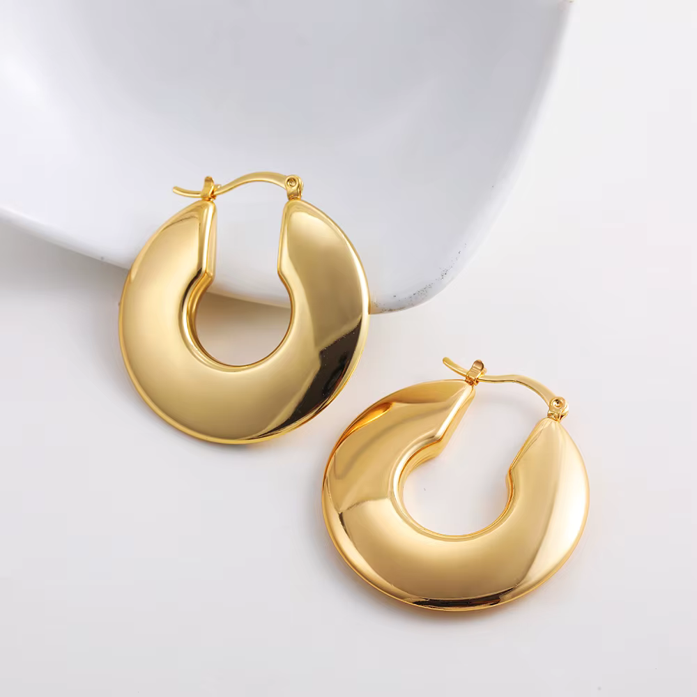 Gold hoop earrings with a twisted crescent design on a white background
