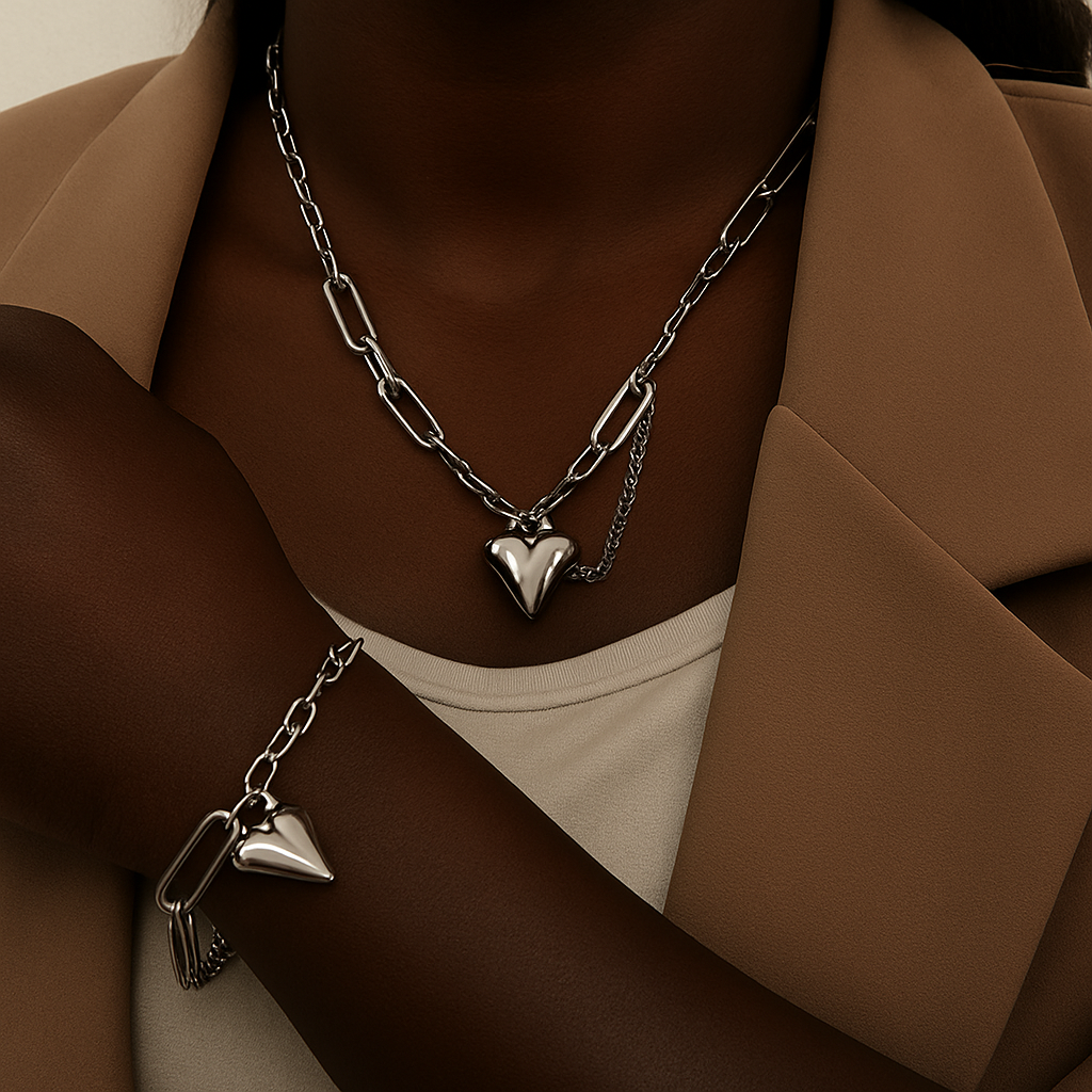 Close-up of a person wearing layered gold necklaces, a bracelet, and a beige jacket over a white top.