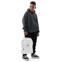 Person holding a white backpack, wearing a dark hoodie, black pants, and black sneakers on a white background