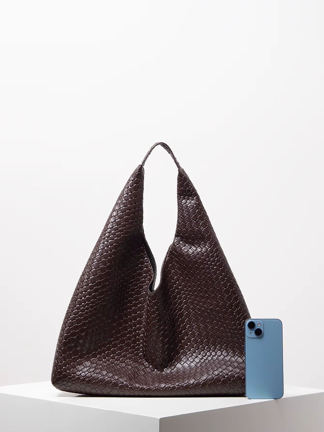 Dark brown woven tote bag with high open handles on a white background