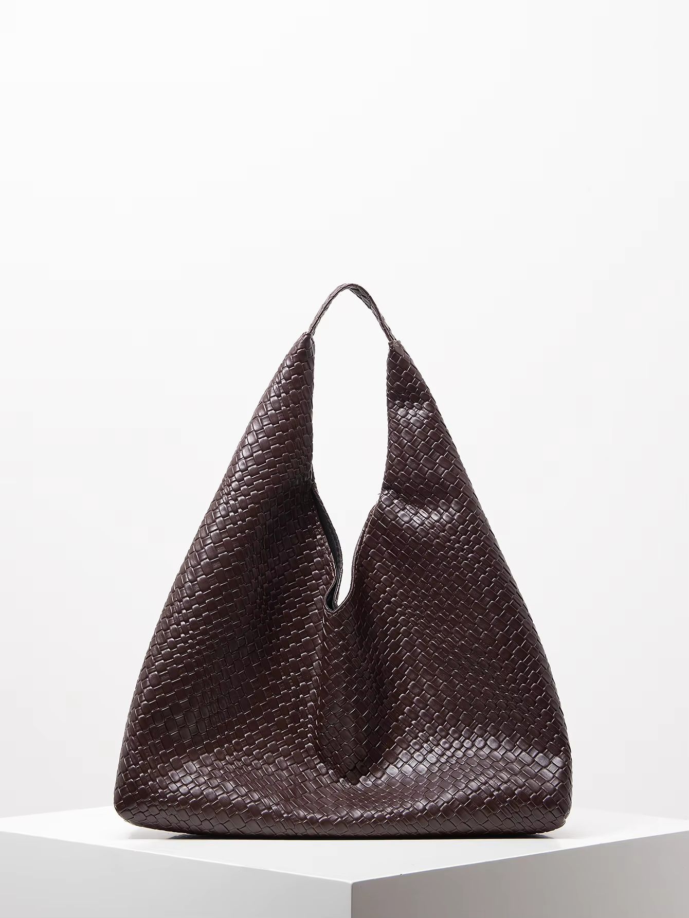 Dark brown woven tote bag with high open handles on a white background