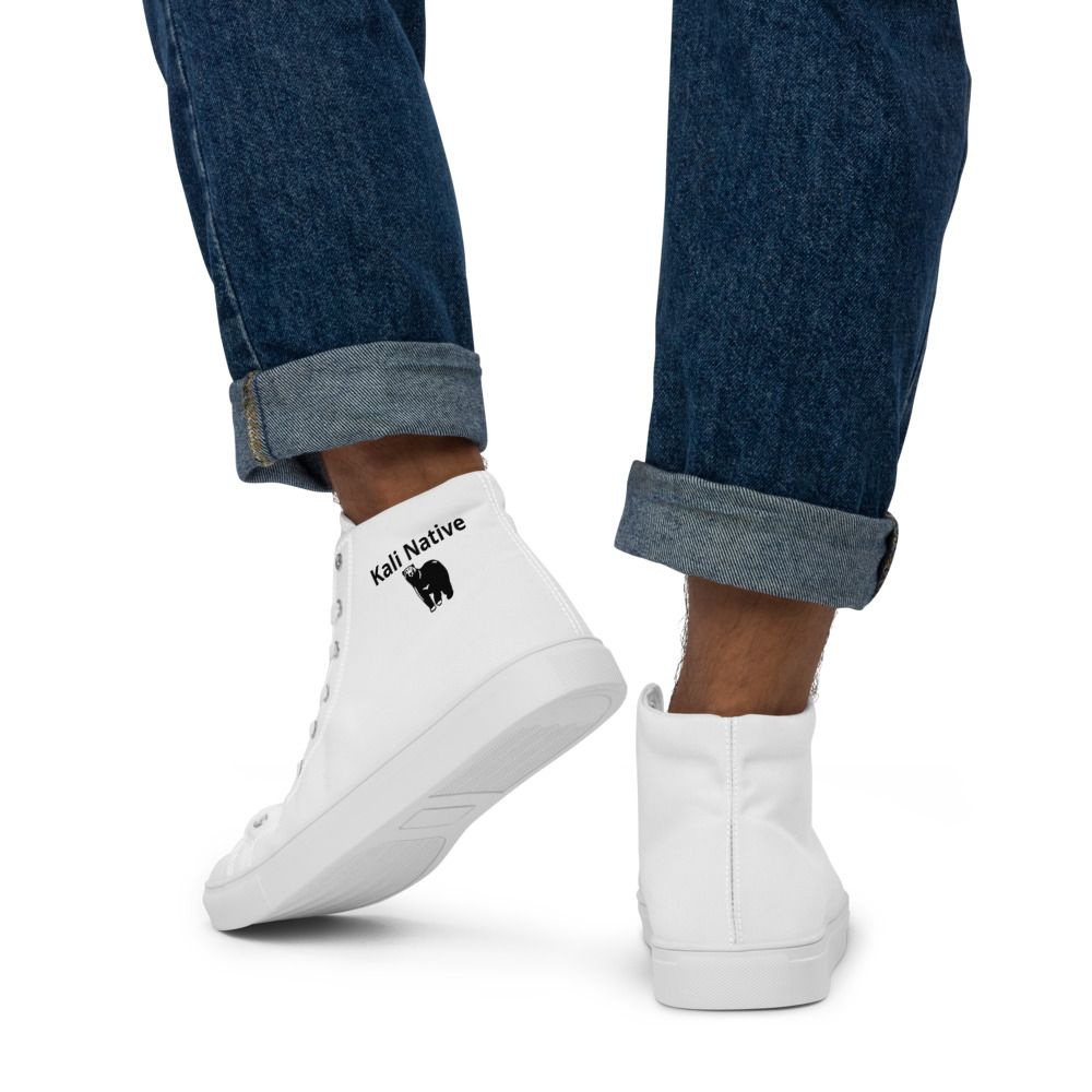 Person wearing cuffed jeans and white slip-on sneakers on a white background