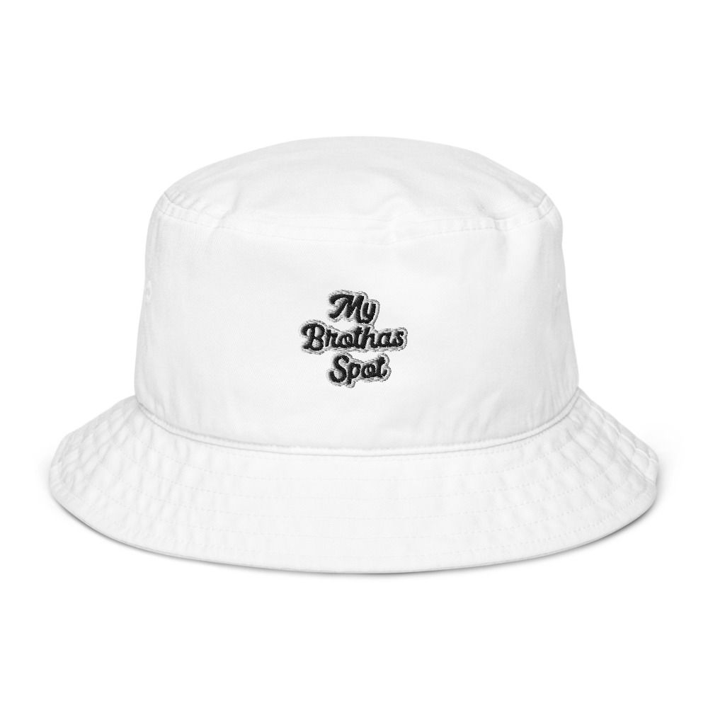 Man wearing a white bucket hat and light gray shirt, smiling against a plain white background