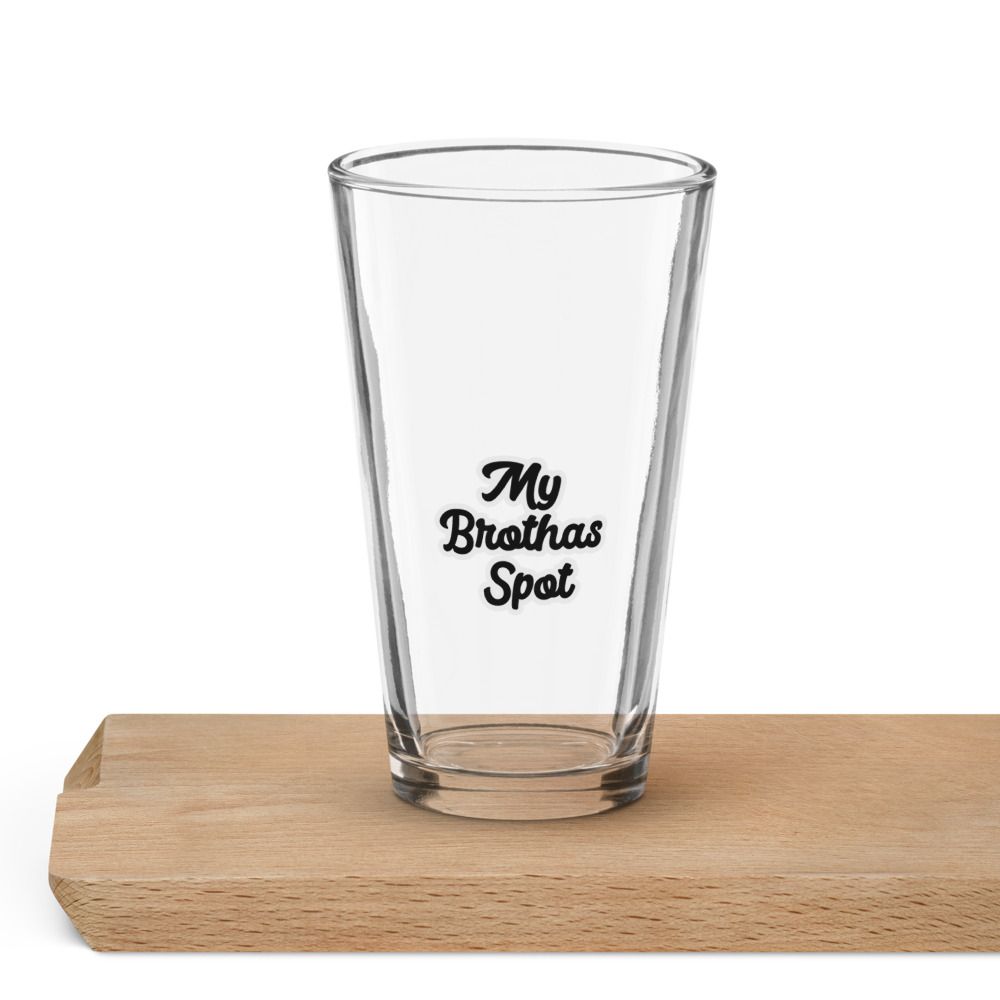 Clear pint glass with “My Brothas Spot” text on a wooden surface