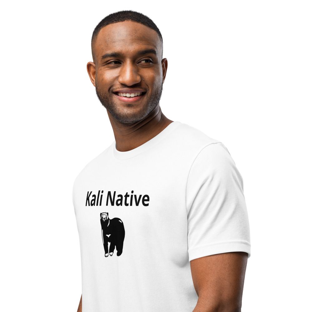 Smiling man in a white T-shirt with “Kali Native” text and a black bear graphic on the front