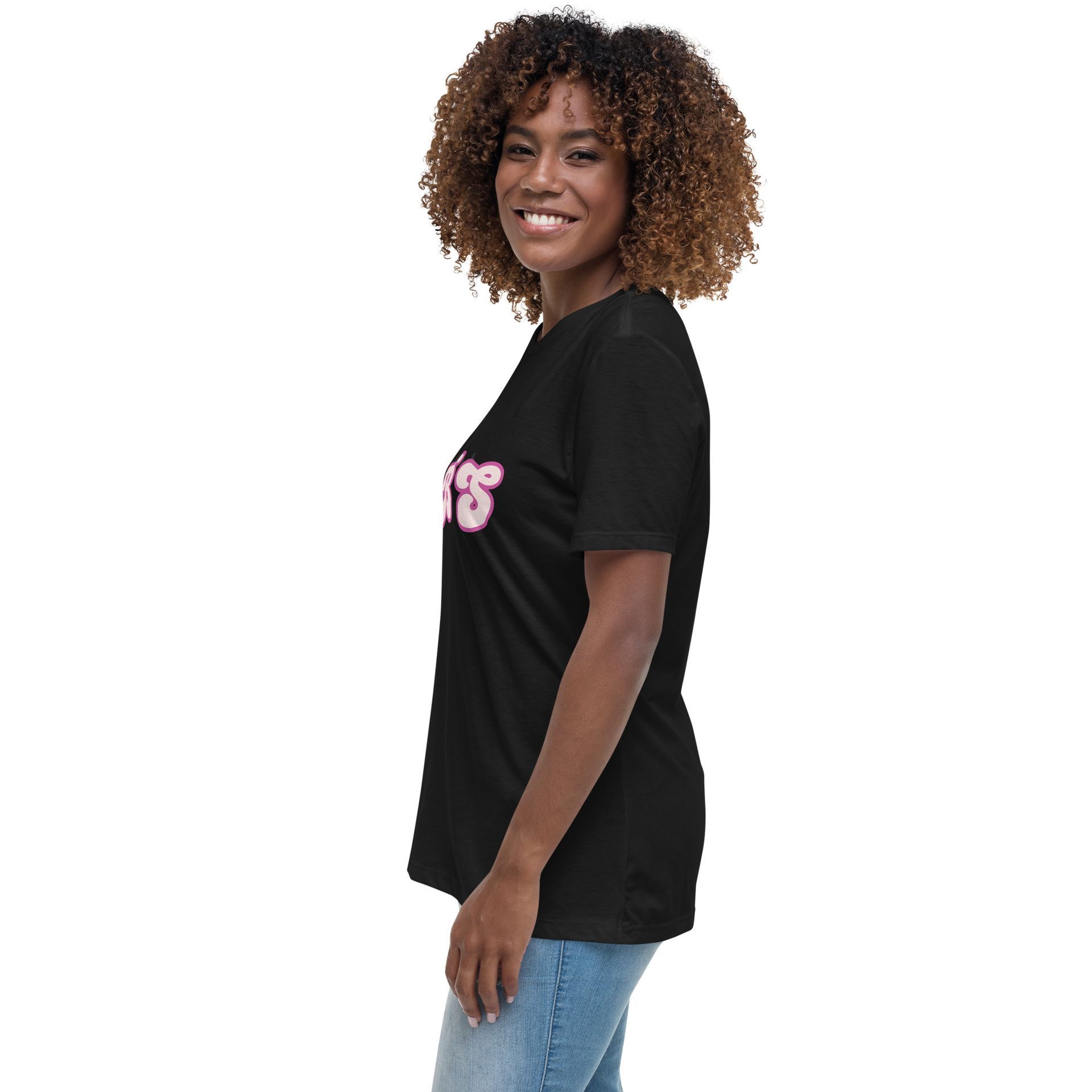 Woman in a black T-shirt and blue jeans, smiling in side profile against a white background