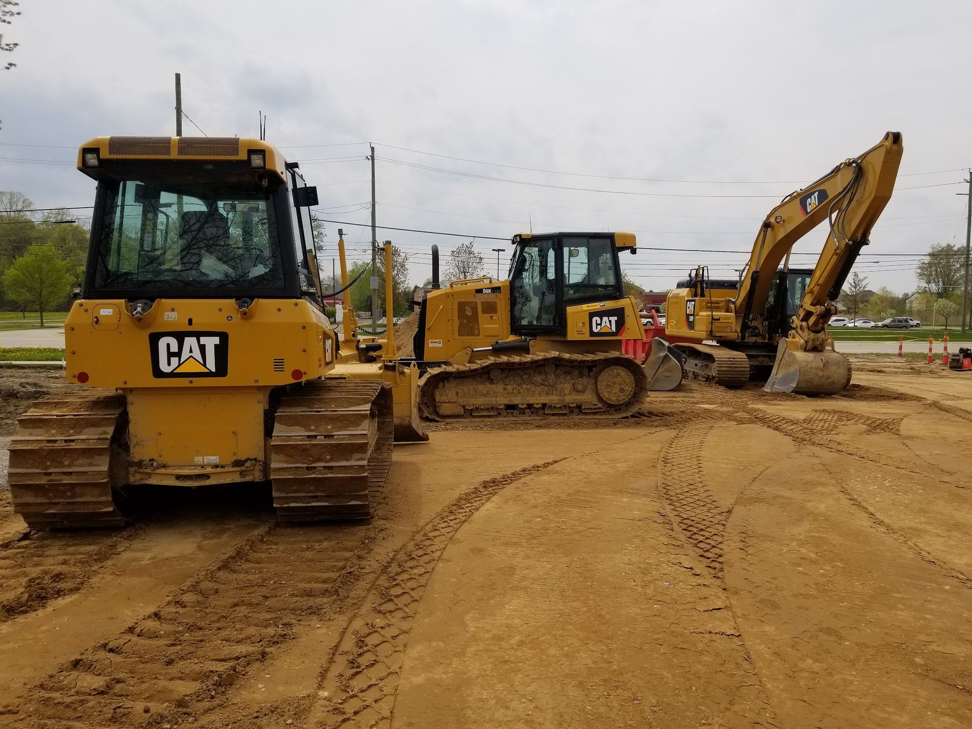 Yellow Caterpillar construction vehicles on a sandy construction site.