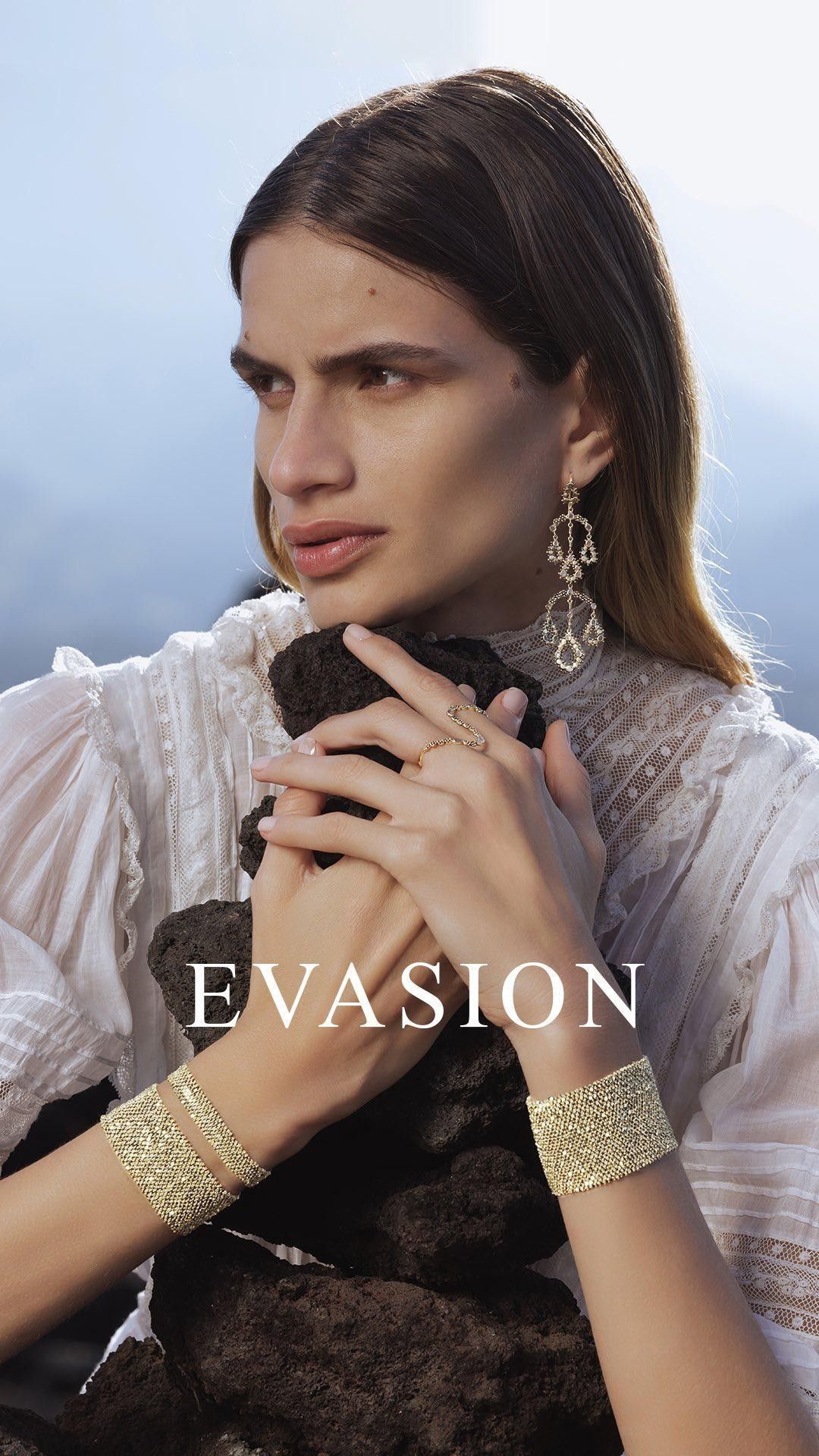 Femme portant des bijoux, une robe blanche et une pierre, en extérieur. Texte « ÉVASION ».