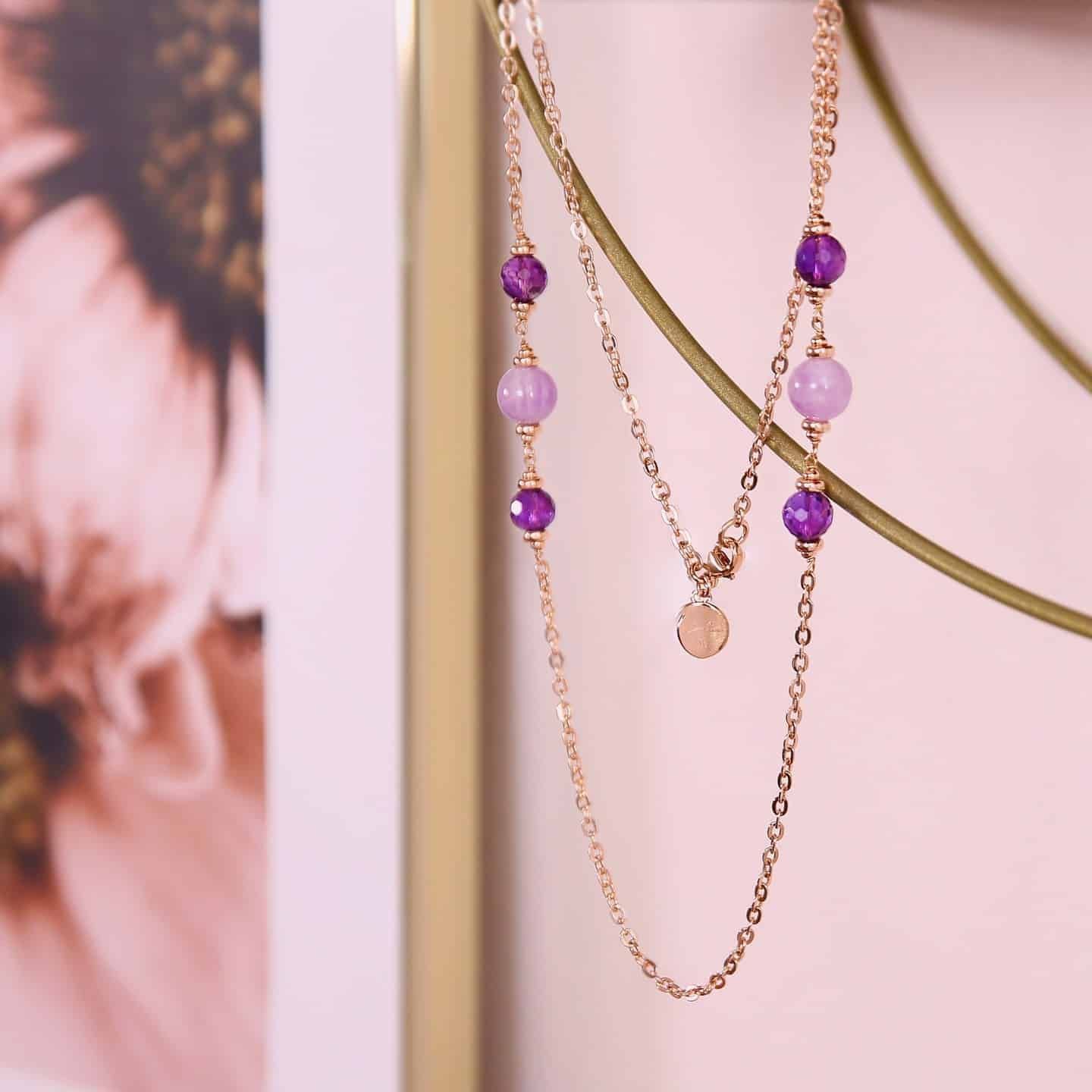 Collier en or superposé avec perles violettes et lavande.