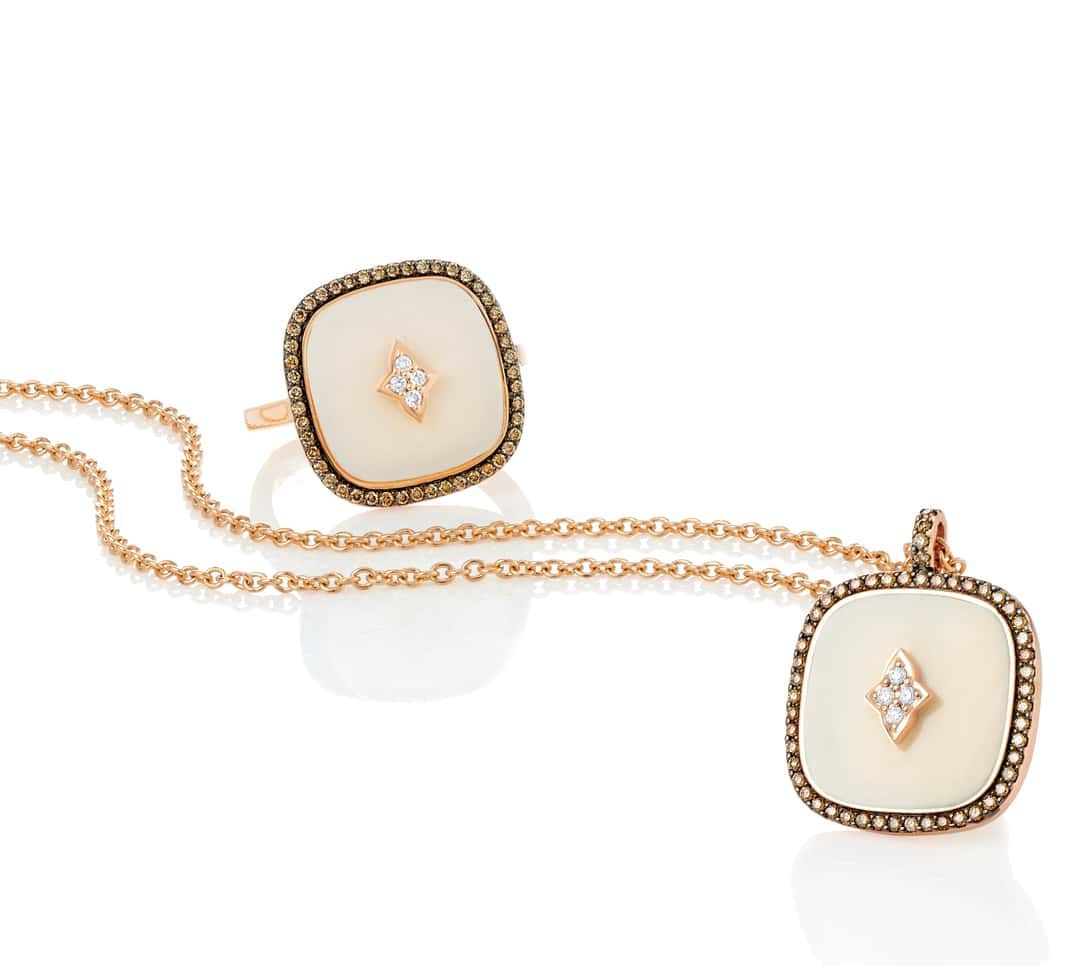 Ensemble bague et pendentif avec centres carrés blancs, entourés de pierres brunes, sur une chaîne en or.
