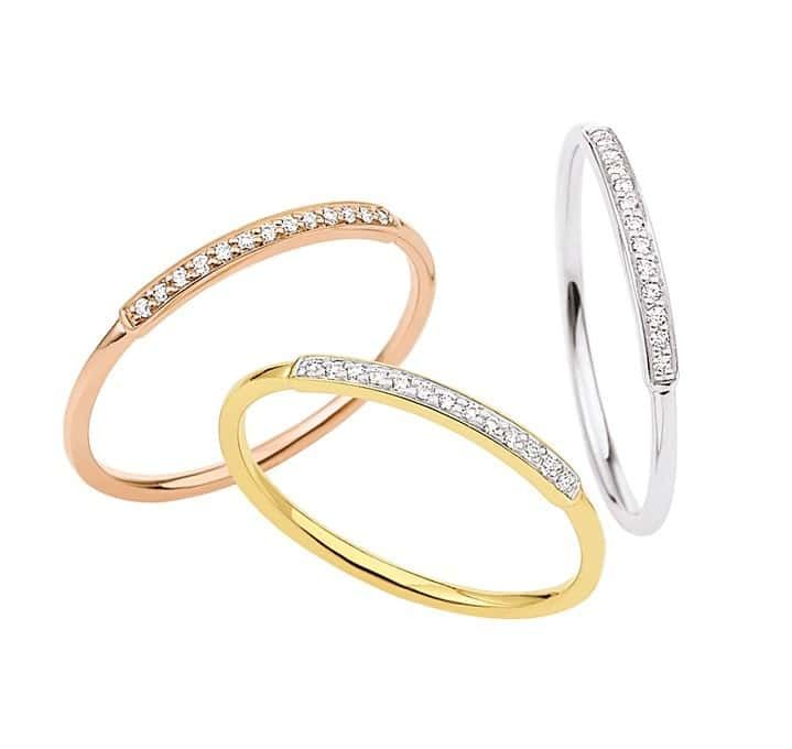 Trois bagues fines : or rose, or jaune et argent, chacune avec une rangée de petits diamants.