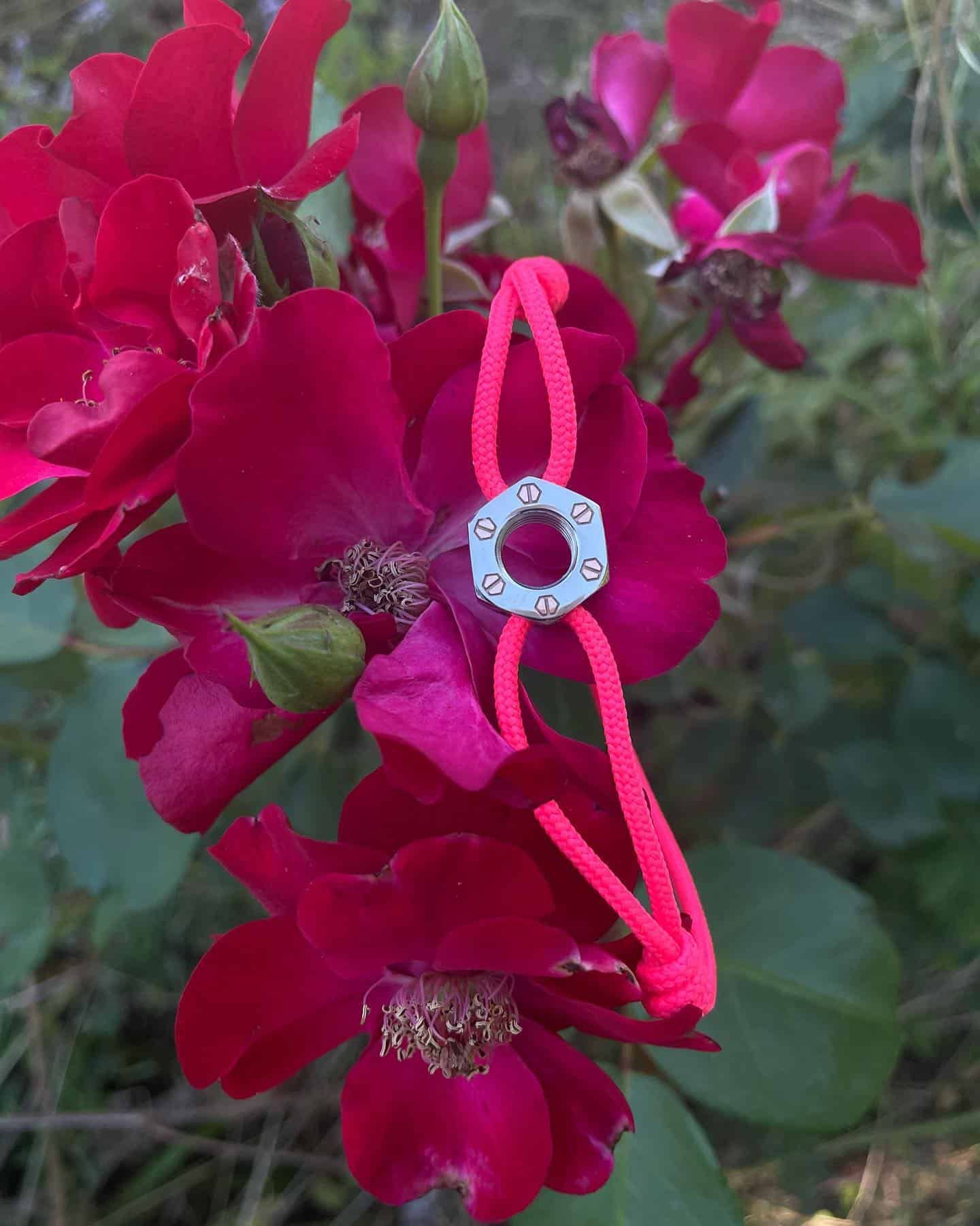 Bracelet rose avec pièce maîtresse blanche sur roses rouges.