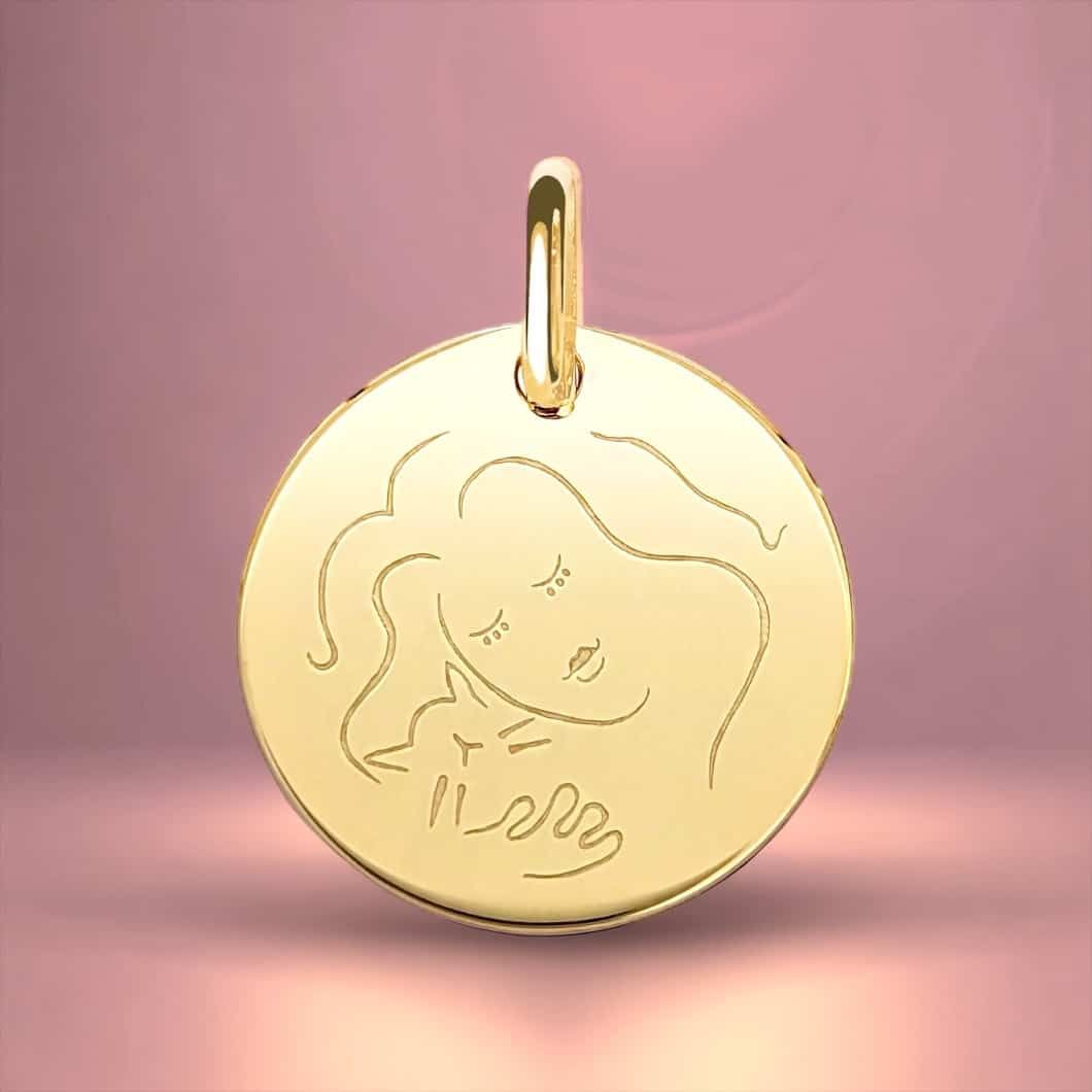 Pendentif en or représentant une image gravée d'une personne tenant un chat.