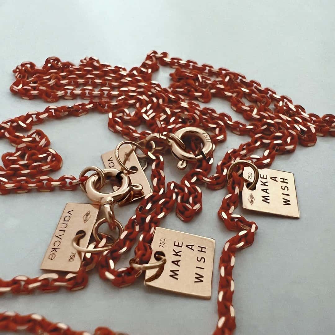 Collier chaîne rouge et or avec trois breloques « Make a Wish ».
