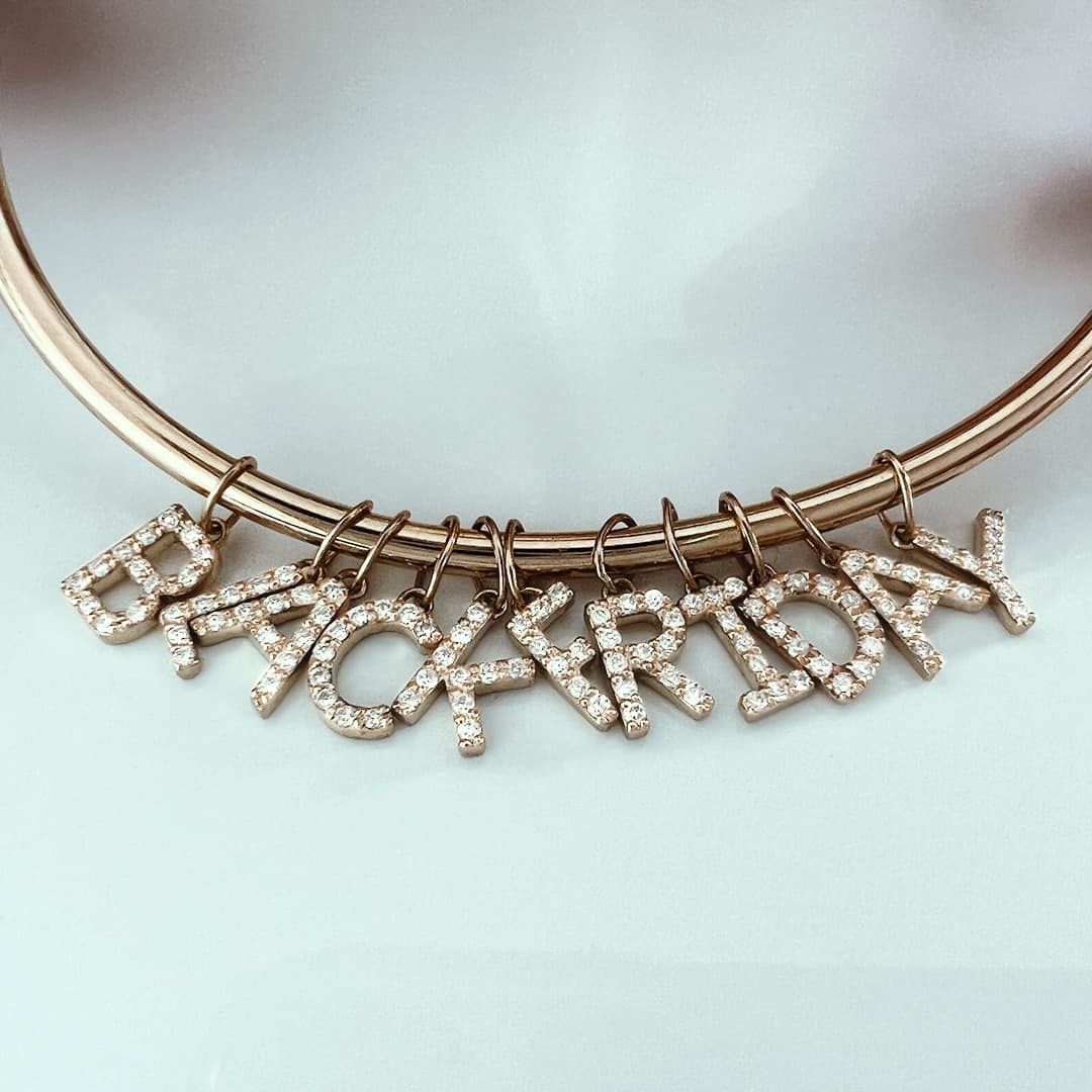Bracelet en or rose avec breloques incrustées de diamants avec l'inscription « BLACK FRIDAY ».