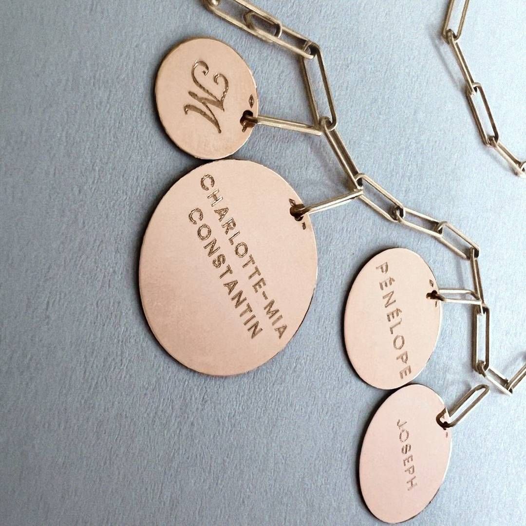Collier en or avec étiquettes rondes gravées, noms et initiales.