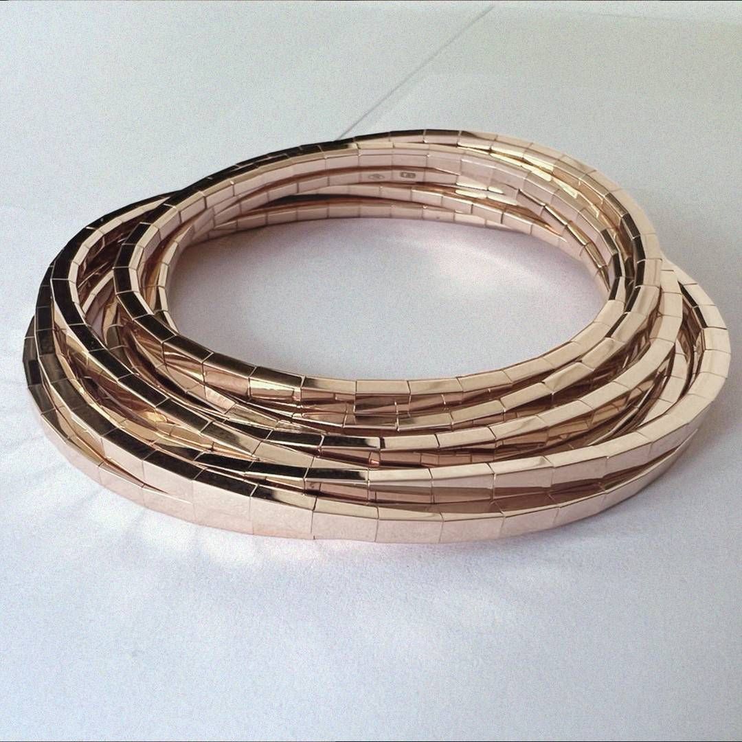 Bracelet flexible en or rose avec plusieurs boucles empilées.