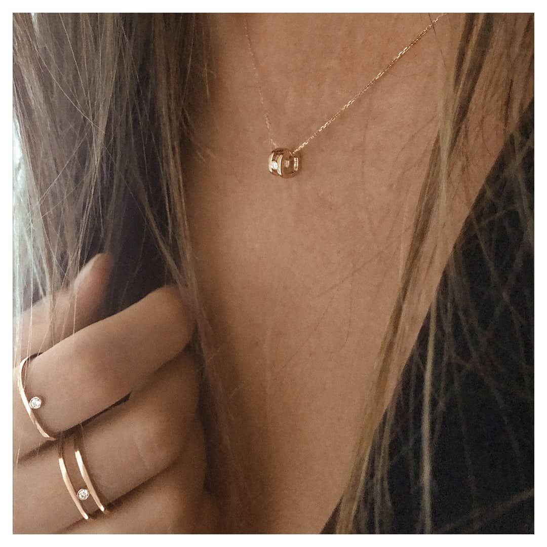 Femme portant un collier en or et des bagues avec de petits diamants.