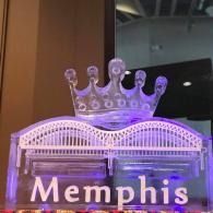 Purple-lit Memphis sign topped with a crown on a building façade