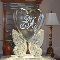 Decorative heart-shaped monogram display with butterfly wings, on a table in a living room
