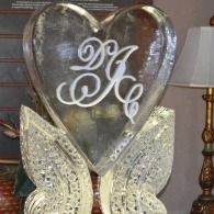 Heart-shaped glass monogram decor with white initials on a sparkling butterfly stand