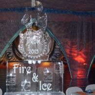 Ice sculpture reading “Fire & Ice” with a crest labeled “PROM 2015” against a dark red-lit backdrop